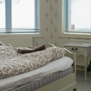 a white bed sitting next to a window in a bedroom
